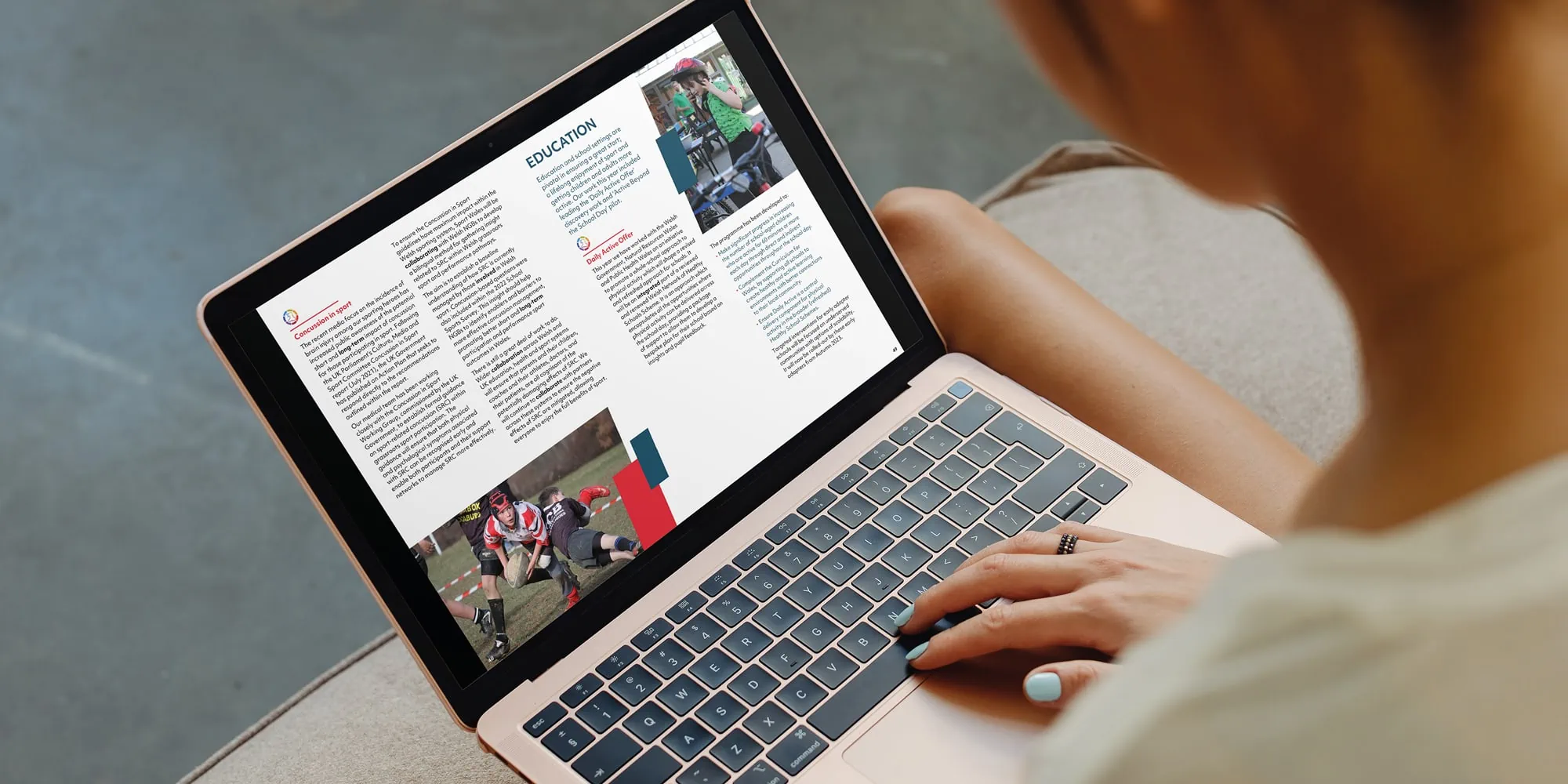 A person viewing the Sport Wales annual report on a laptop.