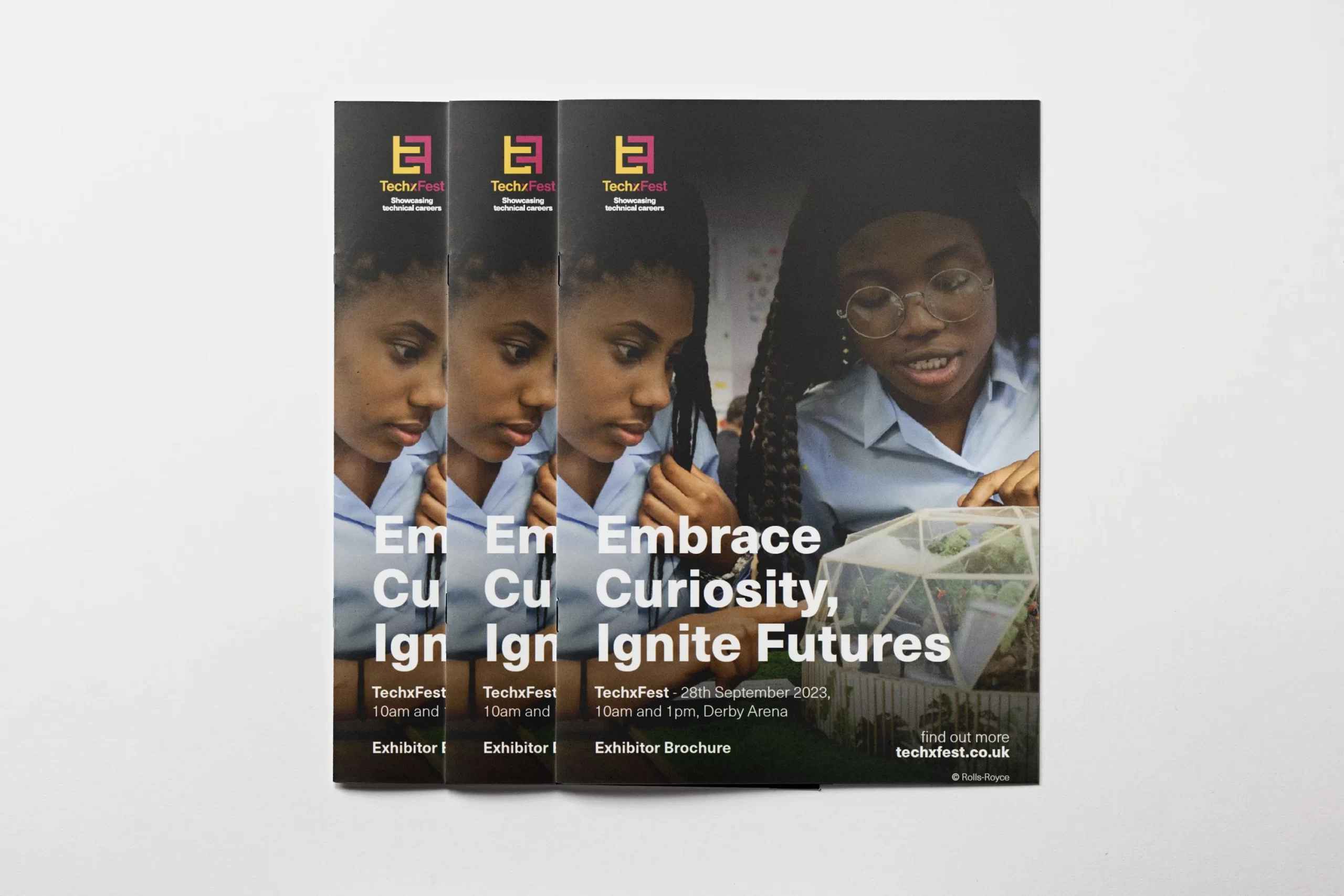 A stack of TechFest exhibitor brochures featuring the tagline "Embrace Curiosity, Ignite Futures" with event details for 28th September 2023 at Derby Arena. The cover shows two people engaged in an activity.