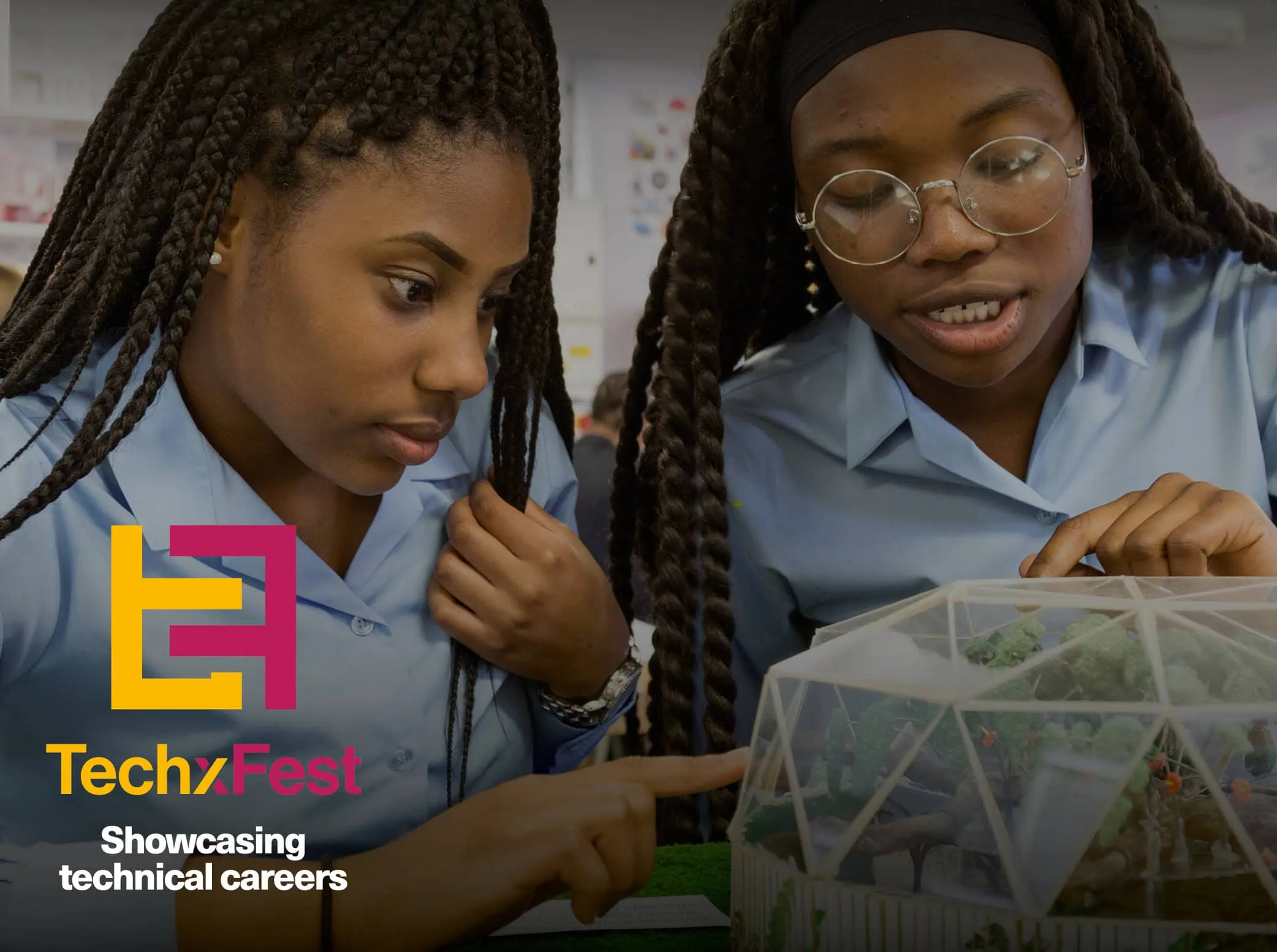 Thumbnail for TechxFest Branding. It shows two young women engaged in a technical project, focusing intently on what appears to be a model or a technical design. The logo for “TechxFest” is prominently displayed in the bottom left corner, featuring the letters ‘T’ and ‘F’ in a stylised design with yellow and pink colours, accompanied by the tagline ‘Showcasing technical careers’.