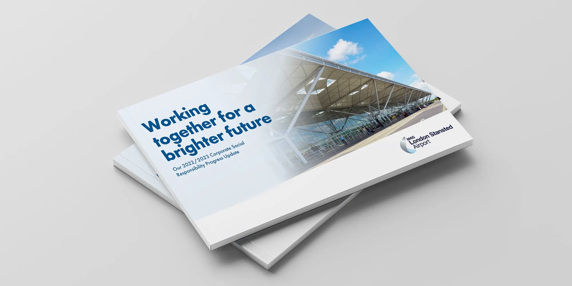 A stack of Corporate Social Responsibility reports designed for London Stansted Airport, titled "Working together for a brighter future."