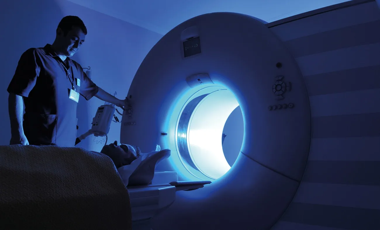 A technician operates advanced medical imaging equipment.