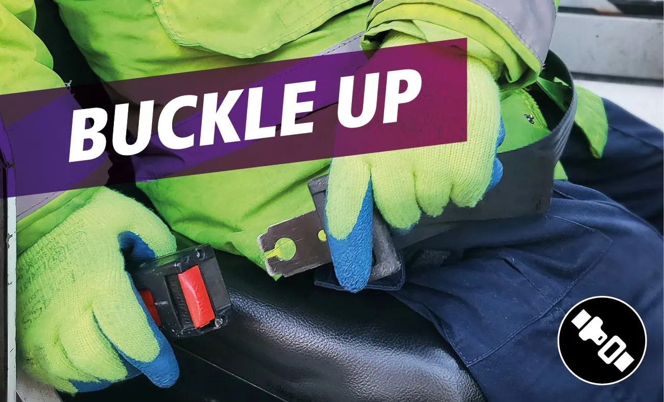 A graphic showing a person fastening a seatbelt, with the text "BUCKLE UP" in bold white letters on a purple gradient banner. A seatbelt icon is displayed in the bottom right corner.