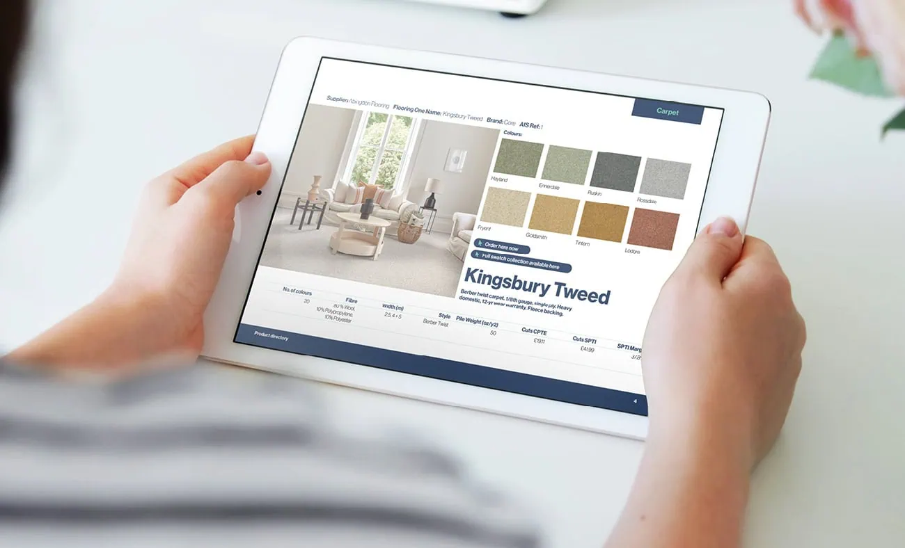 A person holding a tablet displaying a digital catalog featuring fabric options for "Kingsbury Tweed," with a room interior preview and a palette of color swatches.